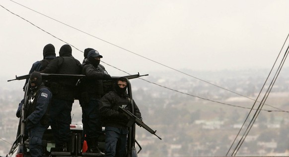 Armed police officials patrol a neighborhood in Tijuana, Mexico, Monday, Jan. 21, 2008. Mexican federal police found an underground shooting range and an arsenal of arms Saturday in this house in down ...