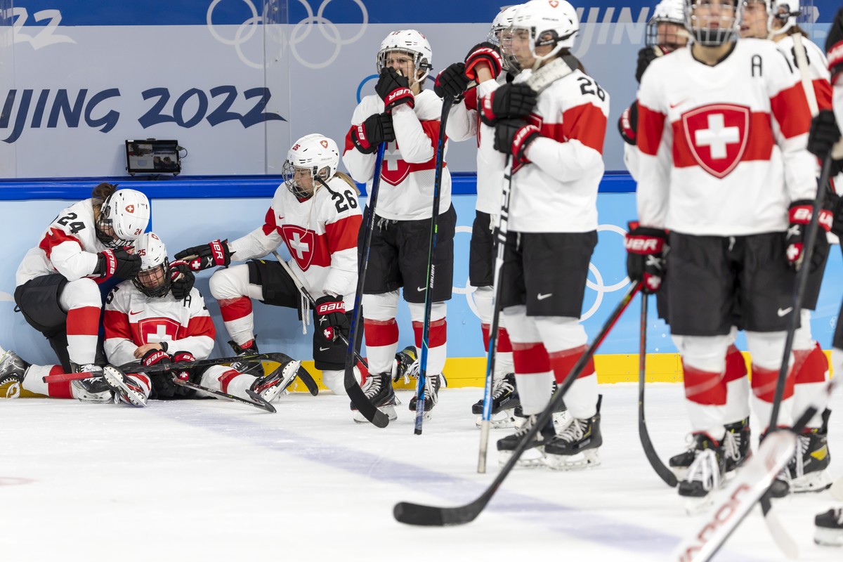 Switzerland's forward Alina Mueller, 2nd left, is comforted by teammates forward Noemi Ryhner, left, and forward Dominique Rueegg #26, after losing the women's ice hockey Bronze Medal game b ...