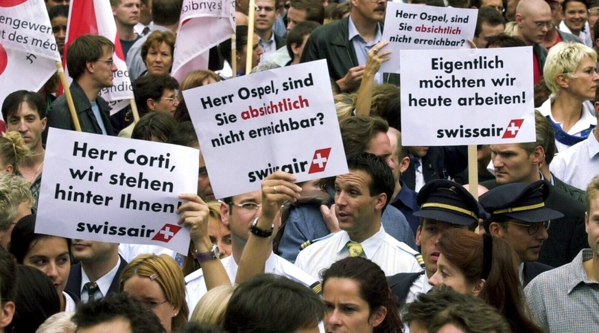 Swissair employees hold signs reading 'Mr Corti, we support you', left, referring to Swissair boss Mario Corti, and 'Mr Ospel, are you absent on purpose?' , center, referring to Ma ...