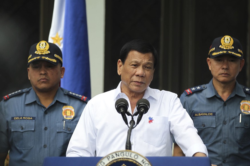 In this photo provided by the Presidential Photographers Division, Malacanang Palace, Philippine President Rodrigo Duterte, center, speaks to erring policemen during an audience at the Presidential Pa ...