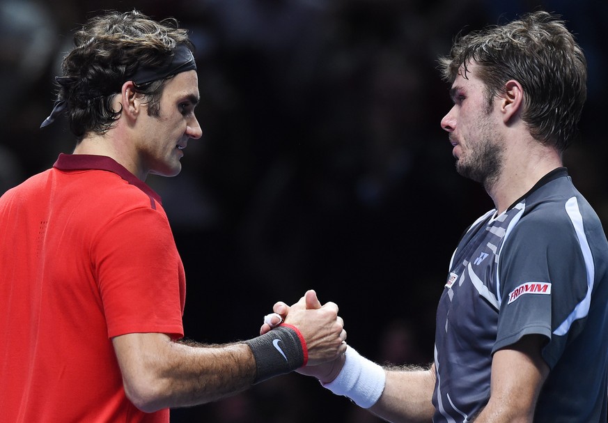 epa04491549 Switzerland's Roger Federer (L) shakes hands with compatriot Stanislas Wawrinka following his three set win during the ATP World Tour Finals semi-final match at the O2 Arena in London ...