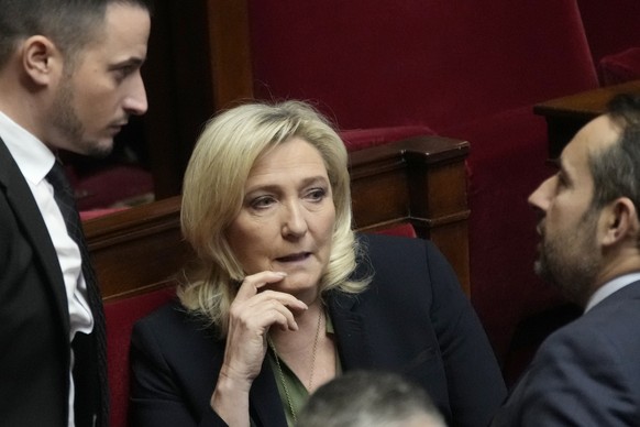 French far-right leader Marine Le Pen talks to members of the National Rally group at the National Assembly, Monday, February 6, 2023 in Paris.  The unpopular planned retirement of French President Emmanuel Macron...