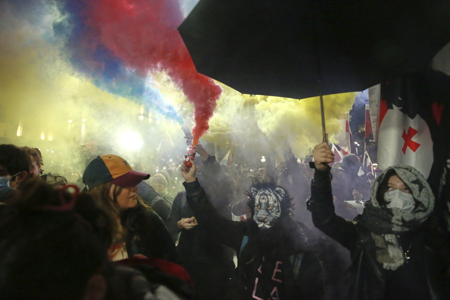 Demonstrators using signal flares, rally to call for the release of political prisoners and demand new elections in the center of Tbilisi, Georgia, Monday, March 31, 2025. (KEYSTONE/AP Photo/Zurab Tse ...