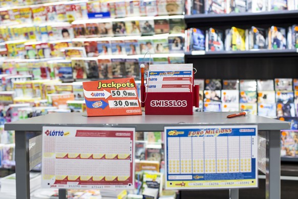 Lottoscheine und eine Tafel mit den Gewinnsummen stehen auf einem Tisch in einem Kiosk im Emmen Center am Samstag, 3. Dezember 2016, in Emmenbruecke. Im Schweizer Zahlenlotto winkt dem Gluecklichen mi ...