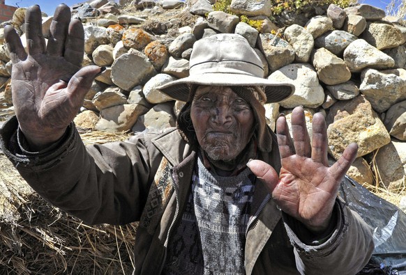 (FILE) Picture taken on August 15, 2013 of Bolivian Carmelo Flores Laura, an Aymara native who claims is 123 years old and if confirmed would be the oldest man alive, waves outside his house in the community of Frasquia, 4050 metres above sea level, on the foothills of the Illampu snowcapped mountain in the Bolivian Andes, some 150 km east of La Paz. Flores Laura died on the eve, a doctor and a family member announced on June 10, 2014.   AFP PHOTO / Aizar RALDES