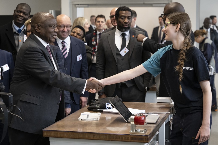epa12493249 President of the Republic of South Africa Cyril Ramaphosa (L) shakes hands with an apprentice during his visit to the Vocational and Further Education Center in Uzwil, Switzerland, 30 Octo ...