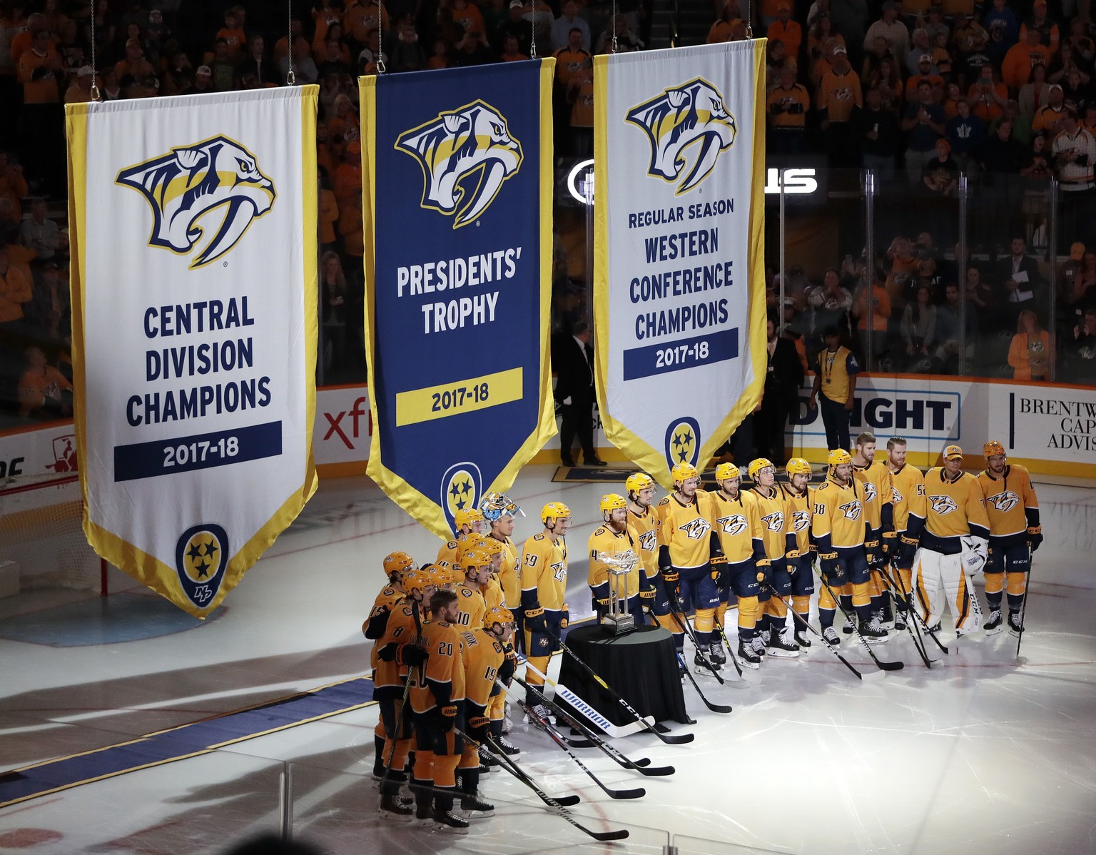 Nashville Predators players stand with the Presidents&#039; Trophy as the banners for the Presidents&#039; Trophy, Central Division Champions and Western Conference Champions are raised before an NHL  ...