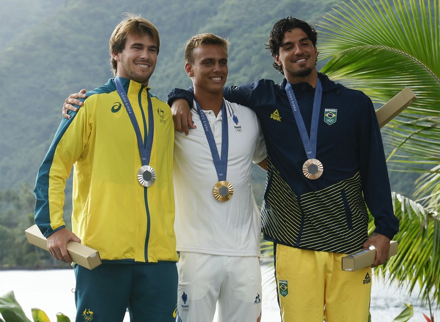 Silver medalist Jack Robinson, left, of Australia; gold medalist Kauli Vaast, center, of France; and bronze medalist Gabriel Medina, right, of Brazil, pose for a photo at the men&#039;s surfing podium ...
