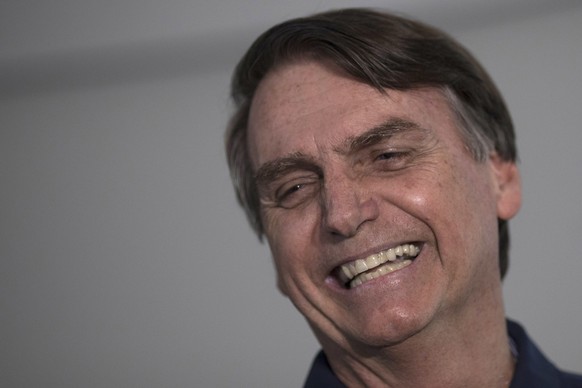 Presidential candidate Jair Bolsonaro, of the far-right Social Liberal Party, smiles during a press conference in Rio de Janeiro, Brazil, Thursday, Oct. 25, 2018. Bolsonaro will face Fernando Haddad,  ...