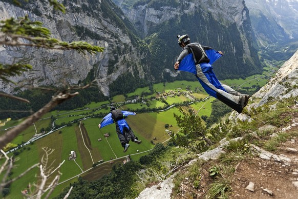 Two basejumpers fall after leaping from the exit point High Nose (550 meters) in the valley of Lauterbrunnen, pictured on august 14, 2011. Since they are wearing wingsuits, their free-fall-time is ext ...