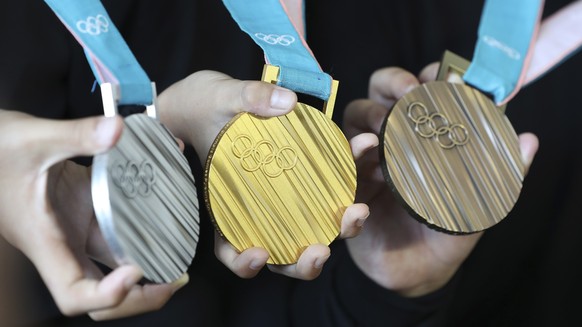 FILE - In this Sep.21, 2017 photo, South Korean athletes pose with the silver, gold and bronze medals, from left, for the Pyeongchang 2018 Winter Olympics during an unveiling ceremony in Seoul, South  ...