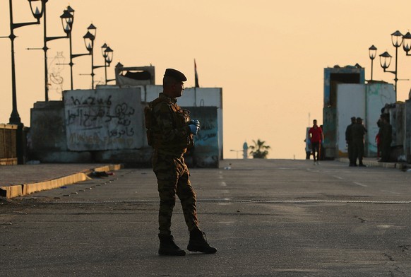A federal policeman mans a checkpoint near the Tigris River in Baghdad, Iraq, Tuesday, March 24, 2020. Iraq is enforcing a curfew to help fight the spread of the coronavirus. (AP Photo/Hadi Mizban)