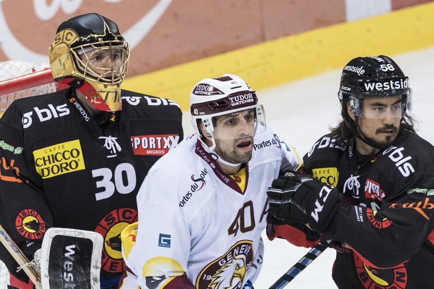 Bern Goalie Leonardo Genoni, Servettes Daniel Rubin und Berns Eric Blum, von links, warten auf den Puck, im Eishockey-Meisterschaftsspiel der National League zwischen dem SC Bern und dem Geneve-Servet ...