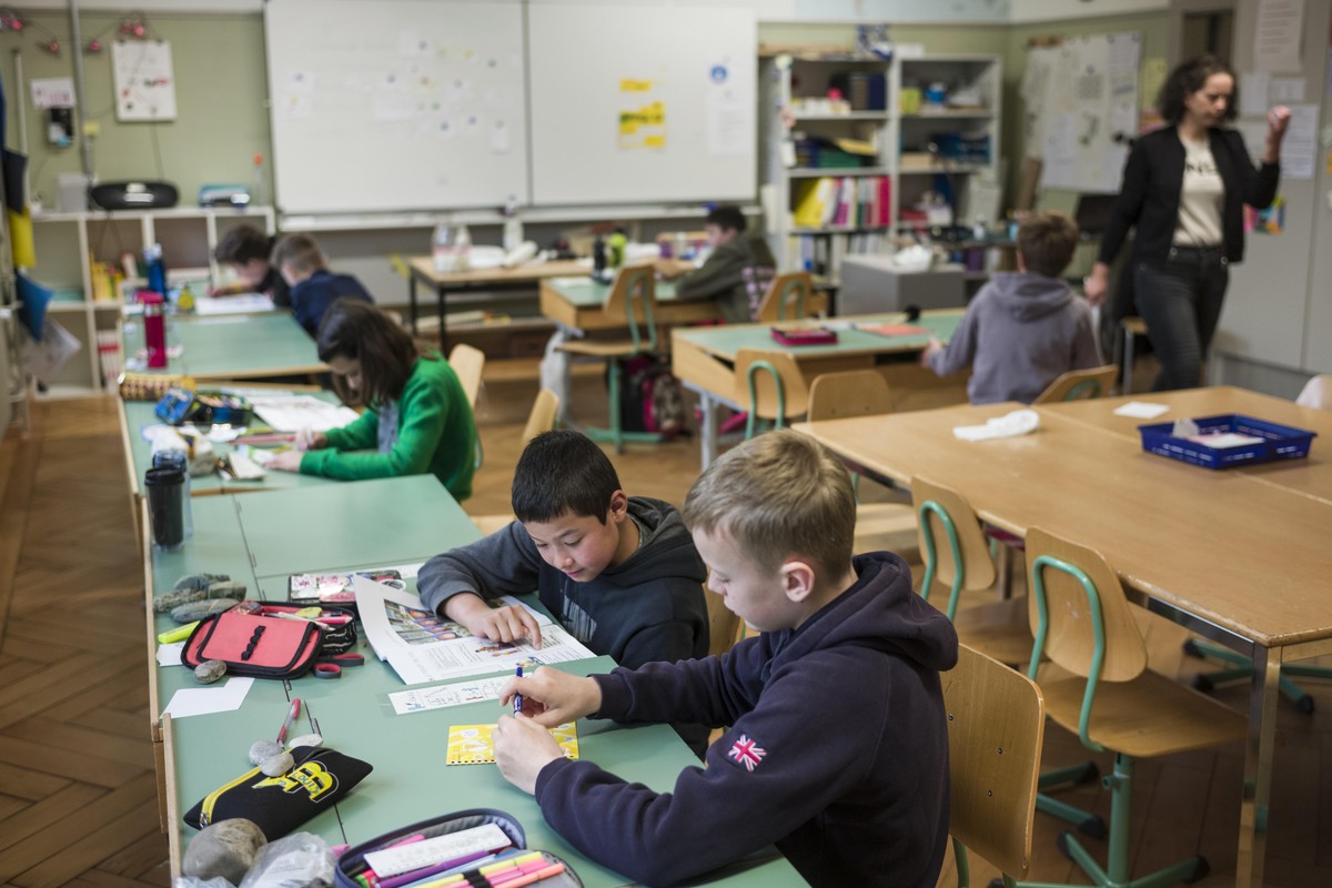 Klassenlehrerin Nina Brunner gibt ihren Schuelerinnen und Schueler der fuenften Klasse, die fuer die ersten zwei Tage je in der halben Klasse anwesend sind, die ersten Arbeiten am Tag der Wiedereroeff ...