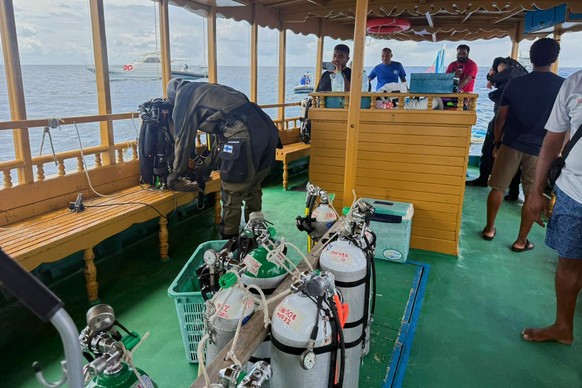 In this handout photo release by Maldives President Media Division, a Finnish diver, left, gets ready to attempt to recover the bodies of two of the four Italians who died deep inside an underwater ca ...