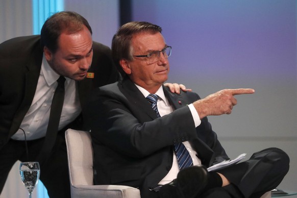 FILE - Carlos Bolsonaro, son of Brazil&#039;s President Jair Bolsonaro who is running for re-election, whispers in his father&#039;s ear during his arrival at the presidential debate in Rio de Janeiro ...