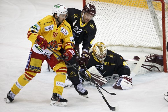 Geneve-Servette&#039;s goaltender Robert Mayer, right, blocks the puck past Biel&#039;s center Luca Cunti #10, and Geneve-Servette&#039;s defender Jonathan Mercier #22, during a National League regula ...