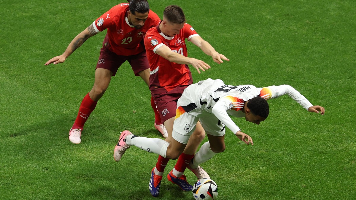 epa11433072 Michel Aebischer (C) of Switzerland tackles Jamal Musiala of Germany during the UEFA EURO 2024 group A soccer match between Switzerland and Germany, in Frankfurt am Main, Germany, 23 June ...