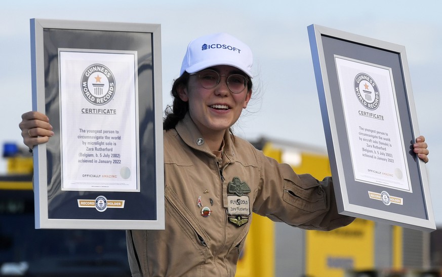 Belgium-British teenage pilot Zara Rutherford holds up her certificates after landing her Shark ultralight plane at the Kortrijk airport in Kortrijk, Belgium, Thursday, Jan. 20, 2022. The 19-year-old  ...