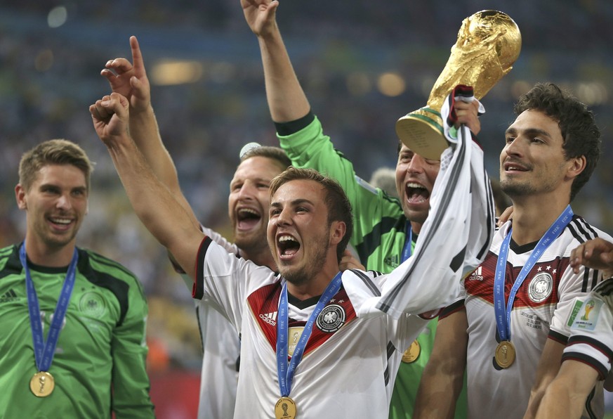 Götze jubelt mit Teamkollegen und WM-Pokal.