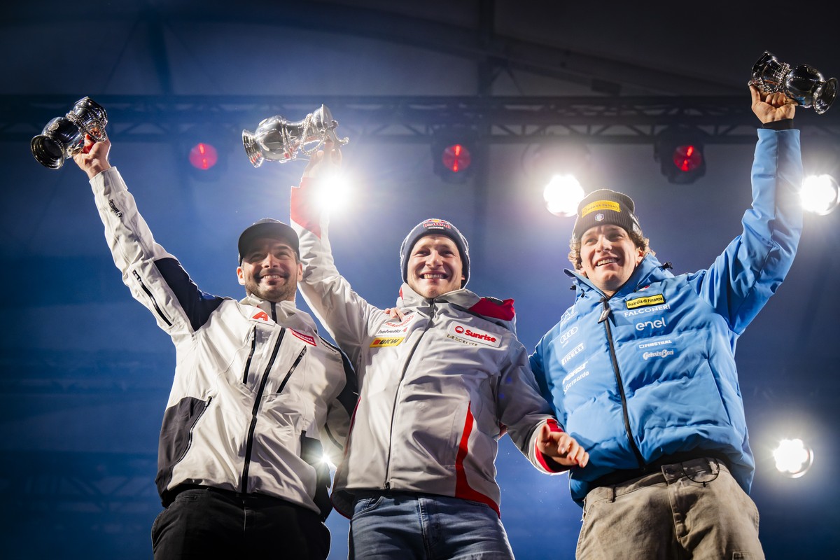 Second placed Vincent Kriechmayr of Austria, left, the winner Marco Odermatt of Switzerland, center, and third placed Giovanni Franzoni of Italy, right, celebrate during the victory ceremony of the me ...