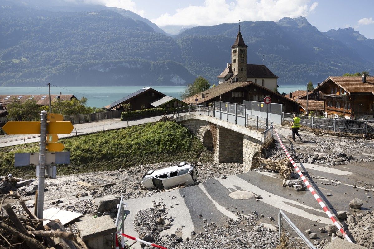 Ein Autowrack liegt in einem verschuetteten Schienenbereich der Eisenbahn, am Freitag, 16. August 2024 in Brienz im Berner Oberland. Am Montag Abend haben heftige Gewitter einen Murgang ausgeloest und ...