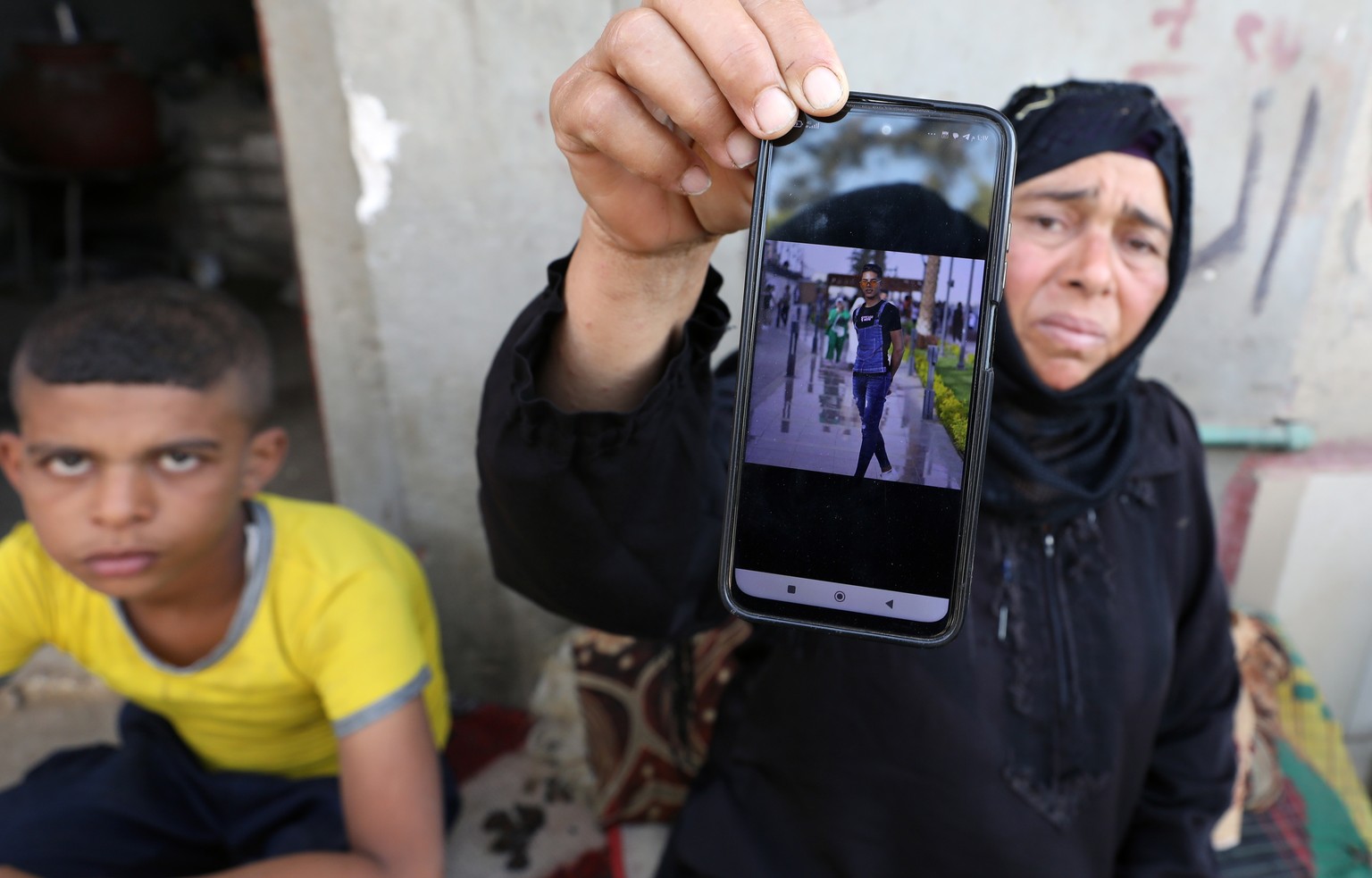 epa10858646 A relative of one of the Egyptian victims, who died in the storm that hit Libya, shows his picture at Kafr Sharif village in Beni Suef, about 120 km south of Cairo, Egypt, 13 September 202 ...