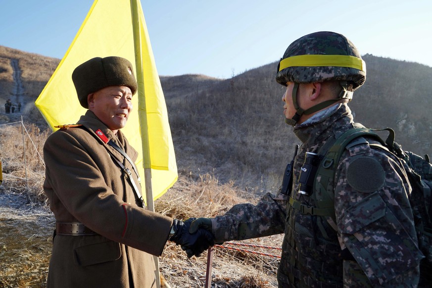 In this photo provided by South Korea Defense Ministry, South Korean army Col. Yun Myung-shick, right, shakes hands with North Korean army Lt. Col. Ri Jong Su before crossing the Military Demarcation  ...