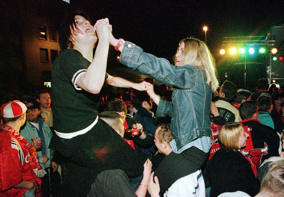 Two women soccer fans of the 1.FC Kaiserslautern (1.FCK) sit on their friend's shoulders while celebrating their team's winning of the German first division soccer championship in downtown o ...