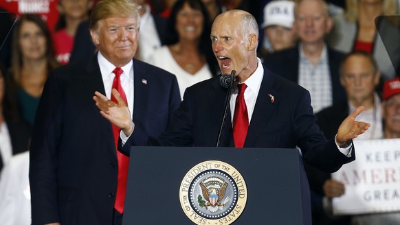 President Donald Trump stands behind Senate candidate, Florida Gov, Rick Scott as he speaks at a rally, Saturday, Nov. 3, 2018, in Pensacola, Fla. (AP Photo/Butch Dill)