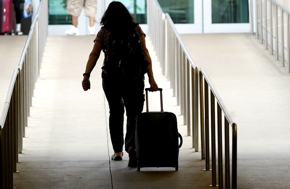 A traveler pulls their bag into the Love Field airport in Dallas, Friday, July 1, 2022. (AP Photo/LM Otero)