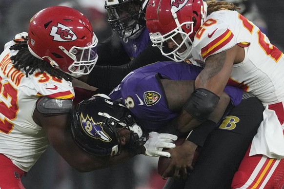 Kansas City Chiefs safety Justin Reid (20) and Chiefs linebacker Nick Bolton (32) sack Baltimore Ravens quarterback Lamar Jackson (8) during the second half of the AFC Championship NFL football game,  ...