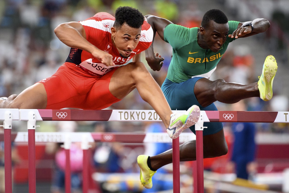 epa09390852 Jason Joseph of Switzerland (L) competes next to Gabriel Constantino of Brazil (R) in the Men's 110m Hurdles heats during the Athletics events of the Tokyo 2020 Olympic Games at the O ...