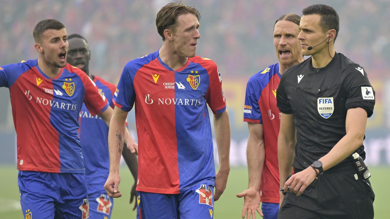 Schiedsrichter Alessandro Dudic laesst sich von Basels Spielern Michael Lang, Wouter Burger und Darian Males, von rechts, nicht von seinem Penalty-Entscheid abbringen im Fussball Meisterschaftsspiel d ...