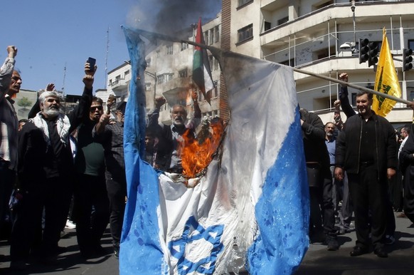 epa11260312 Iranians react as they burn an Israeli flag during a rally marking Al Quds Day in Tehran, Iran, 05 April 2024. Al-Quds Day was declared in 1979 by the late Ayatollah Khomeini, founder of t ...