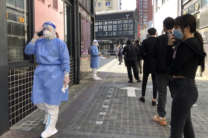 Residents line up for mass testing in a lockdown area in the Jingan district of western Shanghai, Monday, April 4, 2022. China has sent more than 10,000 health workers from across the country to Shang ...