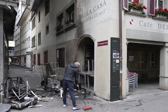 KEYPIX - Nazim Ates, Mitarbeiter des Restaurants Della Case, reinigt den Platz vor dem Restaurant, am Tag nach der nicht bewilligten Demonstration fuer Gaza, am Sonntag, 12. Oktober 2025 in Bern. Bei  ...