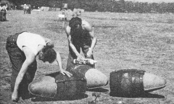 &#039;Beer bombs&#039;, wooden firkins being fitted with streamlined &#039;nose cones&#039; for transporting in bomb racks underneath Spitfires by emembers of 131 Fighter Wing, probably in August 1944