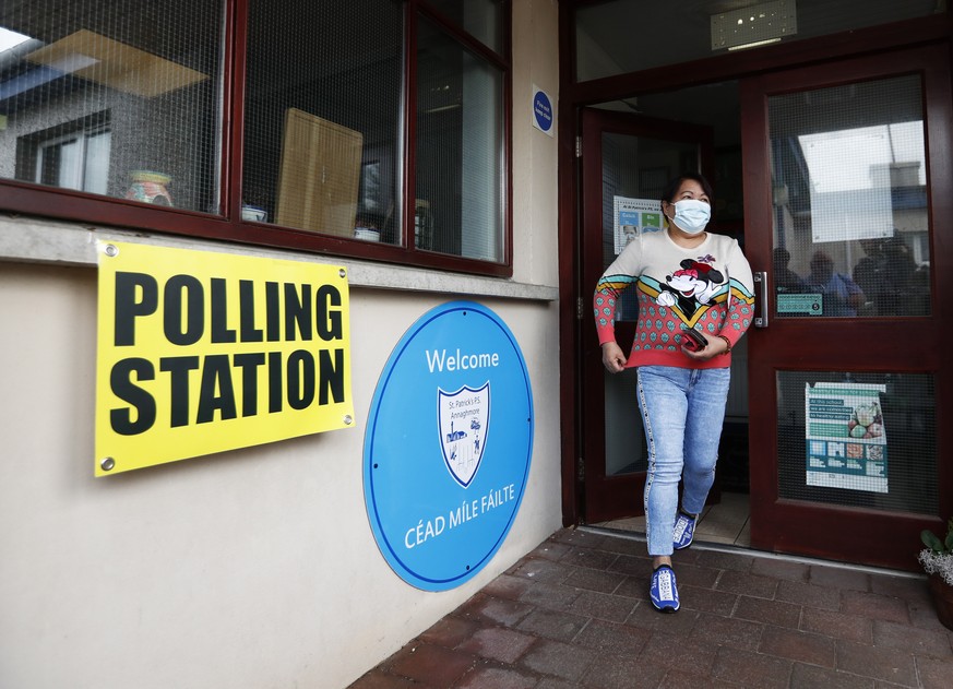 A woman leaves a polling station after casting her vote in Clonoe, Northern Ireland, Thursday May 5, 2022. Sinn Fein, a force in Irish republicanism on both sides of the Irish border looks likely to b ...