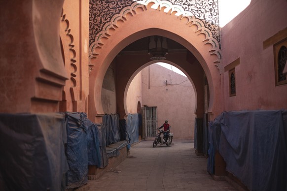 A motorcyclist drives through an empty alleyway in the old Medina of Marrakech, Morocco, Saturday, Dec. 11, 2021. Morocco extended its border closure until the end of the year due to the new covid var ...