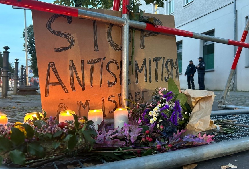 18.10.2023, Berlin: Kerzen stehen vor einem Schild mit der Aufschrift «Stop Antisemitismus» bei einer Mahnwache gegen Antisemitismus nach dem versuchten Brandanschlag in der Nacht zum Mittwoch auf die ...