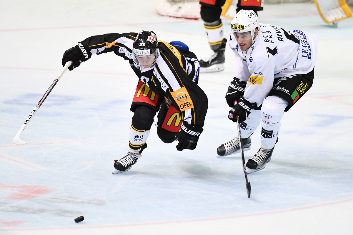 CAPTION CORRECTION: KORRIGIERT NAMEN DES FRIBOURG-SPIELERS Lugano’s player Elia Riva, left, fights for the puck with Fribourg's player Christopher Rivera, right, during the preliminary round game ...