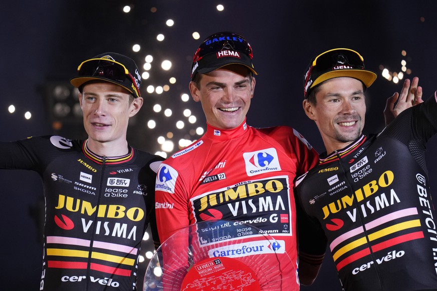 The winner Sepp Kuss of Jumbo-Visma, center, celebrates with teammates, second place Jonas Vingegaard, left, and third place Primoz Roglic on the podium after winning the 21st stage of the Vuelta cycl ...