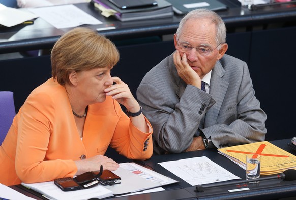 epa04826764 German Chancellor Angela Merkel (L) and German Finance Minister Wolfgang Schäuble (R) talk during a meeting at the German Bundestag in Berlin, Germany, 01 July 2015. The session will focus ...