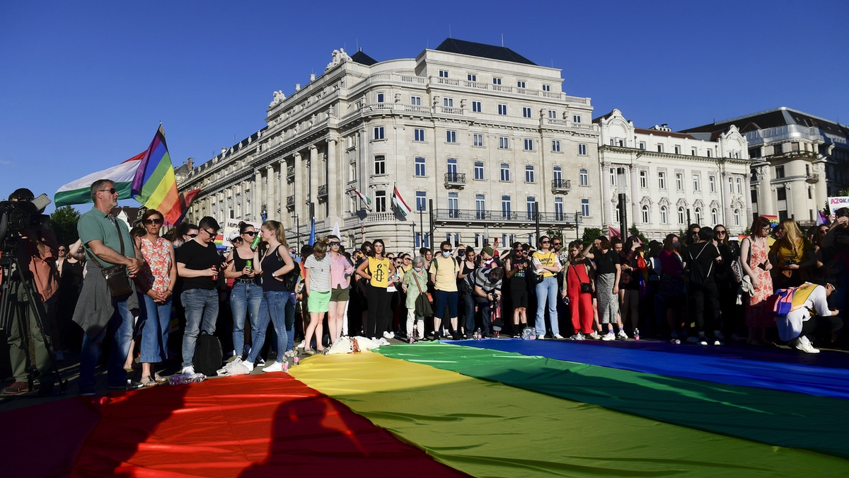 Des gens déploient un drapeau arc-en-ciel lors d'une manifestation pour les droits des LGBT devant le Parlement hongrois à Budapest, en Hongrie, en juin. 14, 2021.