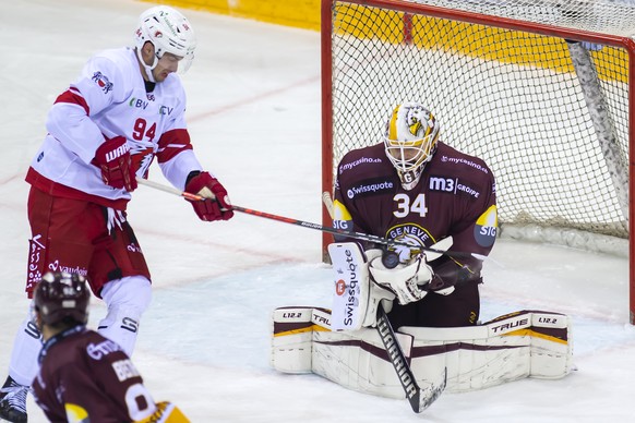 L'attaquant lausannois Tim Bozon, gauche, a la lutte pour le puck avec le gardien genevois Gauthier Descloux, droite, lors du match du championnat suisse de hockey sur glace de National League LNA, entre le Geneve Servette HC et le Lausanne HC, LHC, ce jeudi 28 octobre 2021 a la patinoire des Vernets a Geneve. (KEYSTONE/Martial Trezzini)