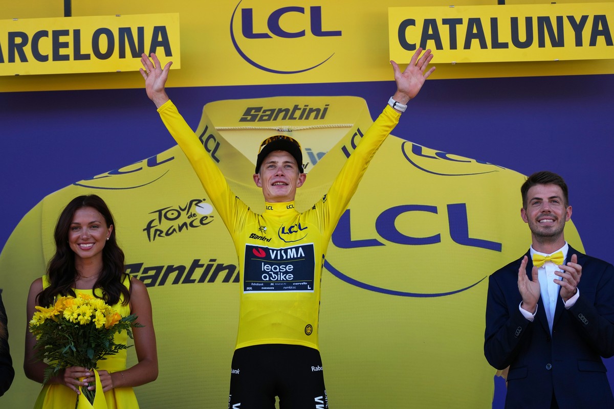 Denmark's Jonas Vingegaard celebrates on the podium after wining the first stage of the Tour de France cycling race, a team time-trial over 19.6 kilometers (11.8 miles) with start and finish in B ...