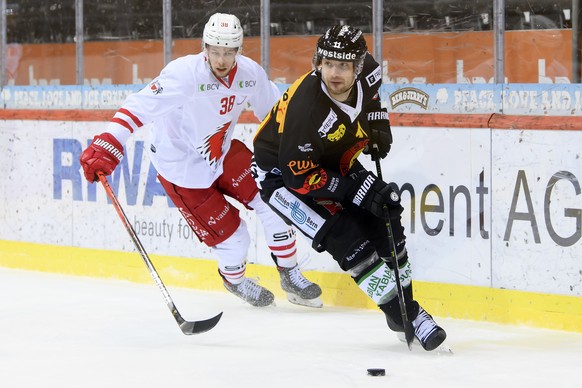 Lausannes Lukas Frick, links, und Berns Alain Berger, rechts, kaempfen um den Puck, beim Eishockey Meisterschaftsspiel der National League zwischen dem SC Bern und den Lausanne HC, in der Postfinance  ...