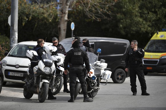 Police cordon off a road during an operation in the southern suburb of Glyfada, in Athens, Greece, Monday, Feb. 12, 2024. Three people have been shot dead at the offices of a shipping company near Ath ...