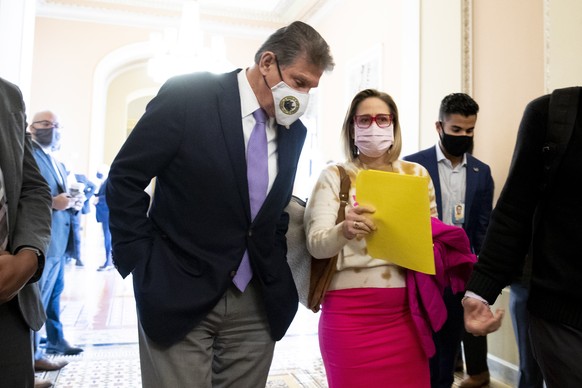 epa09585924 Democratic Senator from Arizona Kyrsten Sinema (R) and Democratic Senator from West Virginia Joe Manchin (L) walk together on their way to the Senate chamber following a Democratic policy  ...